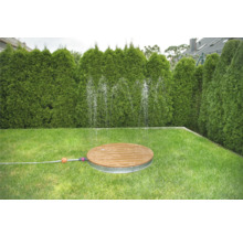 Záhrada s dreveným a kovovým zavlažovačom trávnika