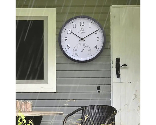 Vonkajšia fotografia nástenných hodín s teplomerom na stene domu