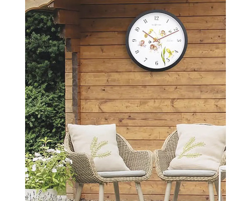 Záhradná scéna s nástennými hodinami, stoličkami a vankúšmi