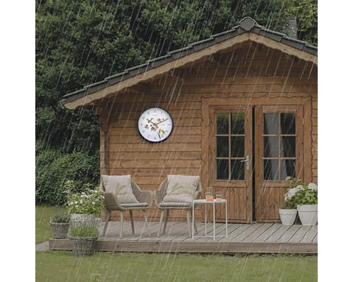 Scéna so záhradným domčekom, záhradným nábytkom a nástennými hodinami v daždi.