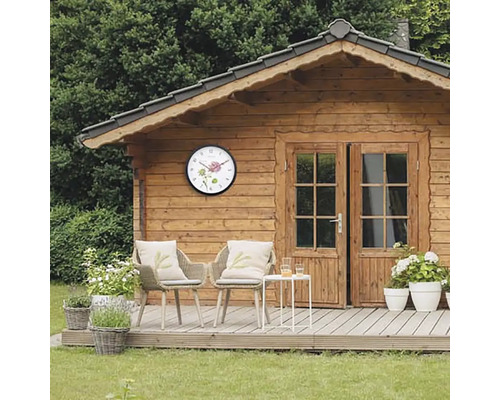 Drevený záhradný domček s nástennými hodinami a posedením na terase