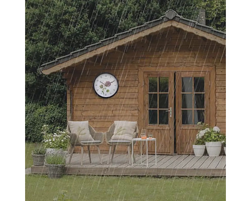 Záhradný domček s nástennými hodinami v daždi, stoličkami a stolom