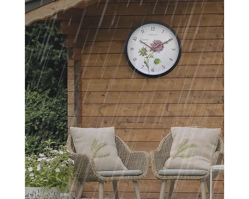 Záhradný domček s vonkajšími hodinami a dvoma ratanovými kreslami s vankúšmi