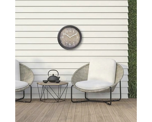 Scéna s vonkajšími hodinami, stoličkami a malým stolom s čajovou kanvicou