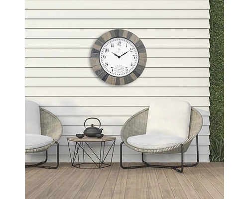 Vonkajší priestor s dvoma stoličkami, stolom a nástennými hodinami