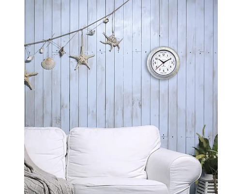 Dekoratívna obývacia izba s nástennými hodinami, pohovkou a námorníckymi dekoráciami