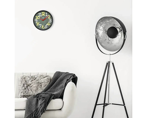 Obývacia izba s pohovkou, stojacou lampou a nástennými hodinami