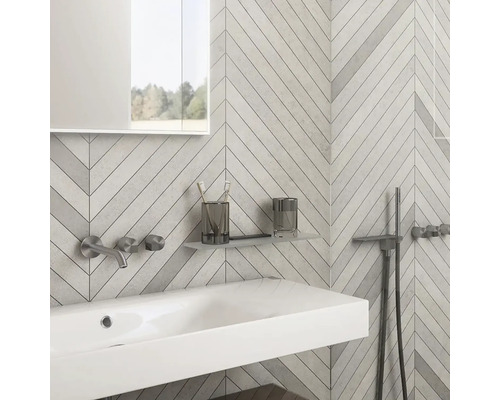 Moderná kúpeľňa s umývadlom, batériou, zrkadlom a obkladmi stien vo vzore rybej kosti