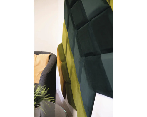 Nástenný panel s trojrozmerným geometrickým dizajnom vedľa kresla.