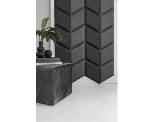 Dekoratívny akustický panel s geometrickým vzorom vedľa príručného stolíka s dekoráciou