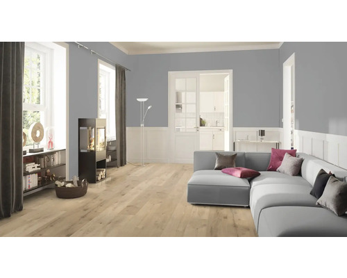 Obývacia izba s pohovkou, krbovými kachľami a svetlou laminátovou podlahou.