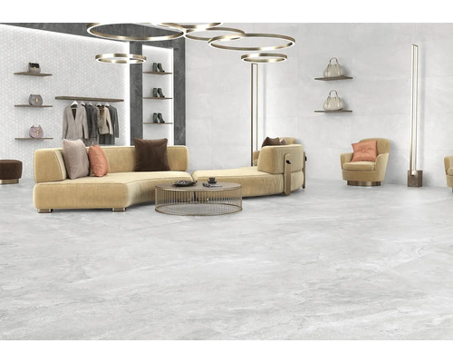 Svetlá miestnosť s pohovkou, kreslami a sivou podlahovou dlažbou s kamenným vzhľadom