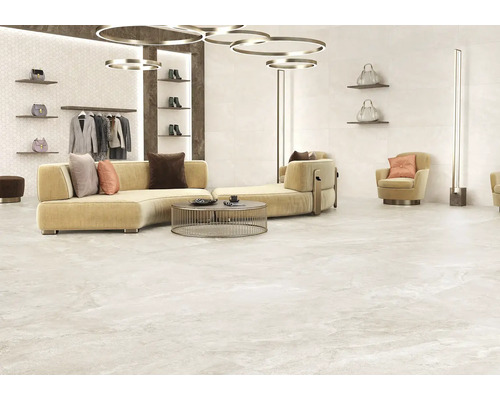 Svetlá, obložená miestnosť s pohovkou, kreslom, vešiakom na oblečenie a dekoratívnymi doplnkami.