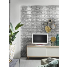 Obývacia izba so sivou tehlovou stenou, televízorom a bielym príborníkom