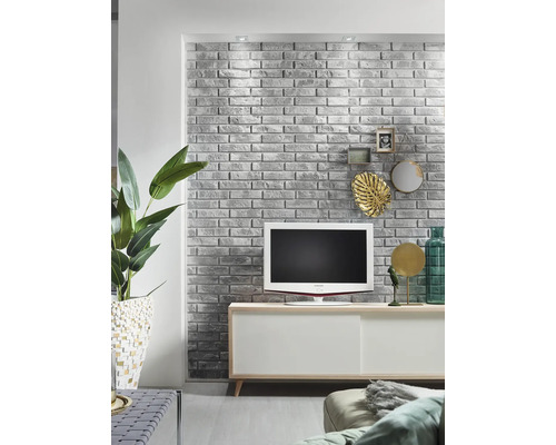 Obývacia izba so sivou tehlovou stenou, televízorom a bielym príborníkom