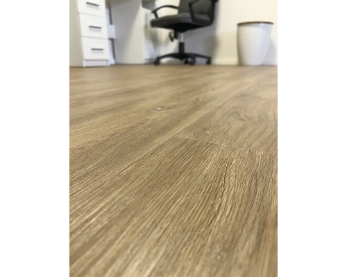 Detail svetlohnedej laminátovej podlahy v kancelárskych priestoroch.