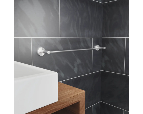 Kovový držiak na uteráky namontovaný v kúpeľni nad umývadlom