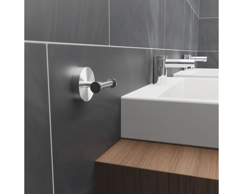 Moderná kúpeľňa so sivými obloženými stenami, umývadlami a háčikom na uteráky.