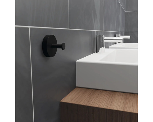 Kúpeľňová scéna s umývadlom, armatúrami a čiernym hákom