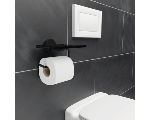 Držiak toaletného papiera s poličkou v kúpeľni.