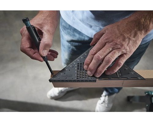 Osoba označuje kus dreva pomocou tesárskeho uholníka a ceruzky