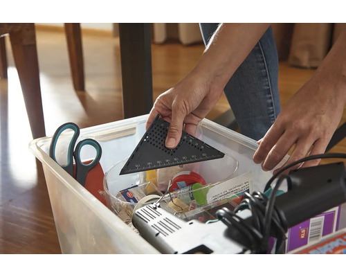 Osoba vkladá uhlomer do úložného boxu s náradím.