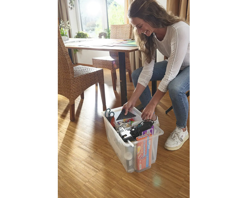 Žena ukladá náradie a materiály do priehľadného úložného boxu.