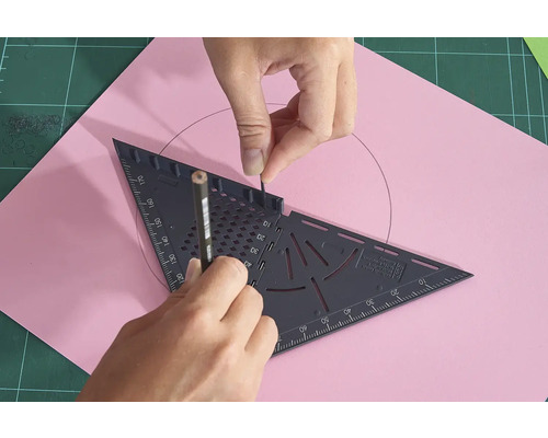 Osoba kreslí ceruzkou a trojuholníkom kruh na ružový list papiera.