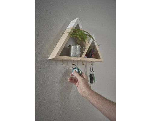 Nástenná polica v tvare hory s háčikmi na kľúče a rukou, ktorá vešia kľúče