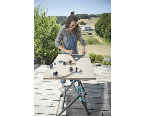 Žena pracuje na obrobku na pracovnom stole vonku.