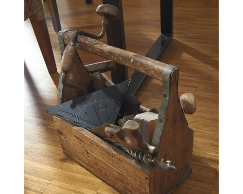 Drevená bedňa na náradie plná náradia, ako je uhlomer, vŕtačka a kladivo