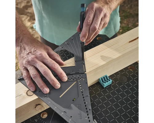 Osoba používa multifunkčný uholník na označenie drevenej dosky.