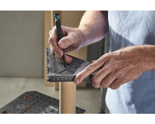 Osoba používa uhlomer a ceruzku na označenie kusu dreva.