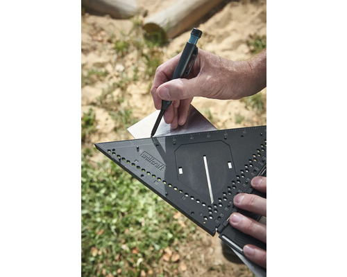 Ruka kreslí čiaru tesárskou ceruzkou s uhlomerom na plech.