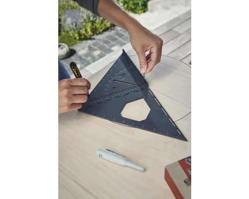 Remeselník pracuje s tesárskym uholníkom na drevenej doske a kreslí kruh.