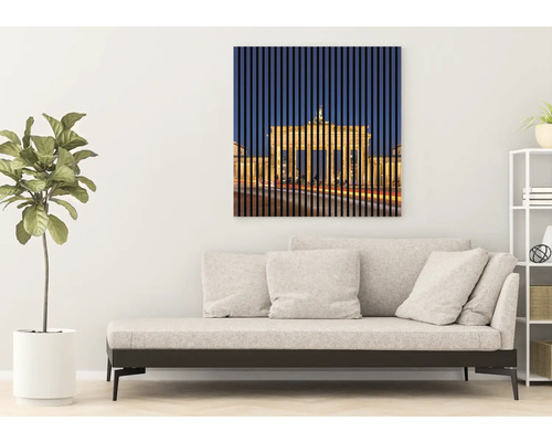 Obývacia izba s pohovkou a nástennou maľbou Brandenburskej brány v Berlíne