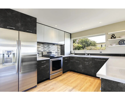 Moderná kuchyňa s nerezovými spotrebičmi a tmavými pracovnými doskami.