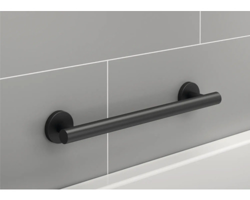 Čierne madlo na sivej stene v kúpeľni.