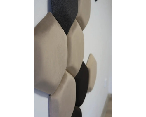 Detail steny s béžovými a tmavými akustickými panelmi v tvare zaoblených päťuholníkov na pohlcovanie zvuku.