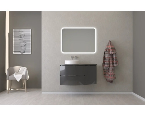 Kúpeľňa s umývadlovou skrinkou, umývadlom, osvetleným zrkadlom a dekoráciou pre svetlú a usporiadanú atmosféru.