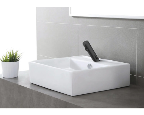 Obdĺžnikové umývadlo na dosku s batériou v modernej kúpeľni.