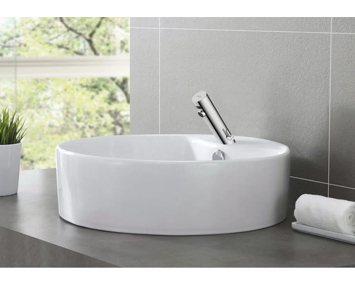 Keramické umývadlo na dosku s batériou v kúpeľni.