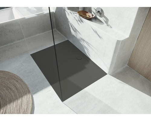 Sprchovací kút v úrovni podlahy s odtokovým žľabom vo svetlej kúpeľni.