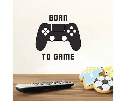 Nálepka na stenu s textom Born to Game a symbolom ovládača, spolu s diaľkovým ovládačom a sušienkami
