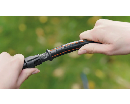 Dve ruky spájajú záhradnú hadicu s konektorom.