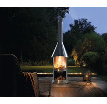 Nerezový terasový krb s drevom na drevenej terase so záhradou v pozadí