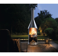 Nerezový vonkajší krb s drevom a ohňom v záhrade