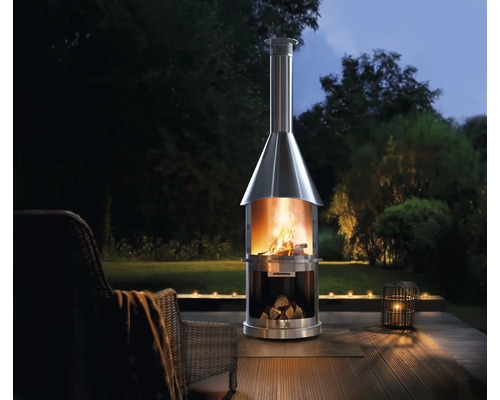 Nerezový vonkajší krb s drevom a ohňom v záhrade