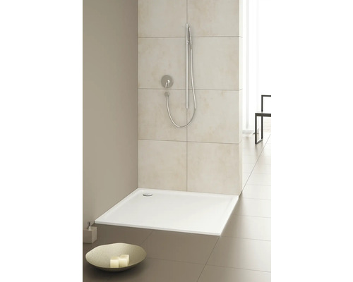 Sprchovací kút v úrovni podlahy so sprchovou hlavicou a batériou vo svetlej kúpeľni.