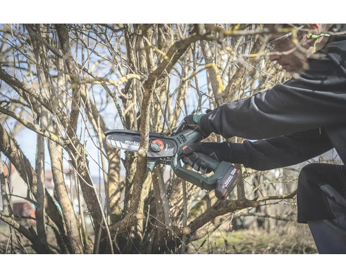 Osoba reže konáre akumulátorovou reťazovou pílou značky Metabo.